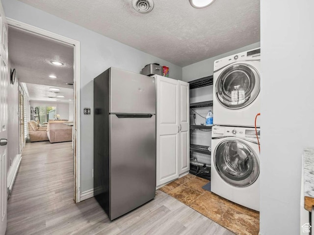 211 N 800 E, Bountiful, UT 84010 - washroom featuring cabinet space, stacked washer and clothes dryer, a textured ceiling, light wood-style floors, and recessed lighting