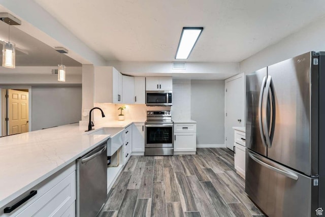 211 N 800 E, Bountiful, UT 84010 - kitchen with stainless steel appliances, dark wood-style floors, white cabinetry, and decorative light fixtures