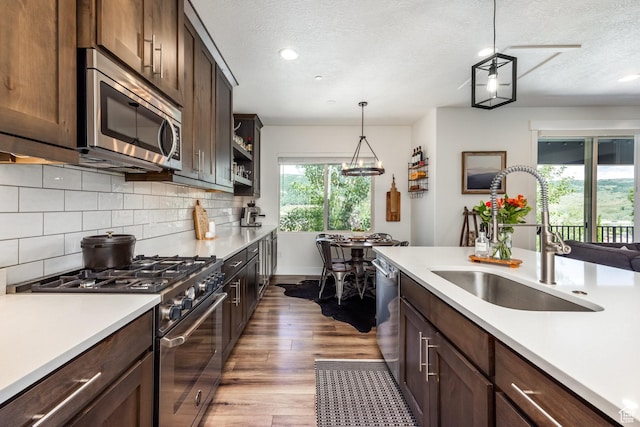 3302 Quarry Springs Dr, Park City, UT 84098 - kitchen with stainless steel appliances, light countertops, tasteful backsplash, a textured ceiling, and light wood-style floors