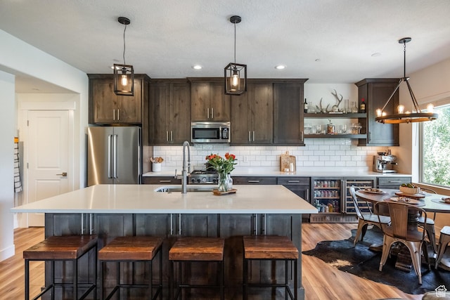 3302 Quarry Springs Dr, Park City, UT 84098 - kitchen featuring appliances with stainless steel finishes, light wood-type flooring, dark brown cabinets, open shelves, and light countertops