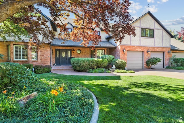 9618 S Ruskin Cir E, Sandy, UT 84092 - tudor house with concrete driveway, a front yard, brick siding, a garage, and roof with shingles