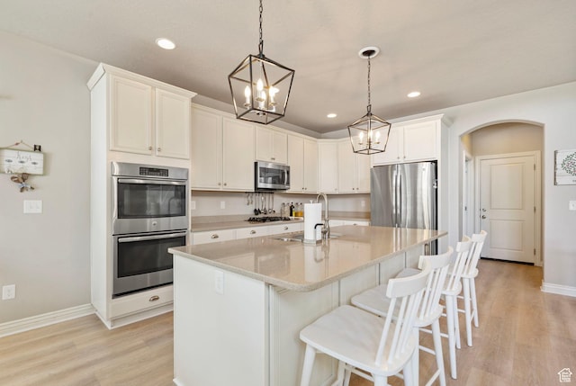 598 W Sandhill Dr, Lehi, UT 84043 - kitchen with appliances with stainless steel finishes, light wood-type flooring, a chandelier, arched walkways, and recessed lighting