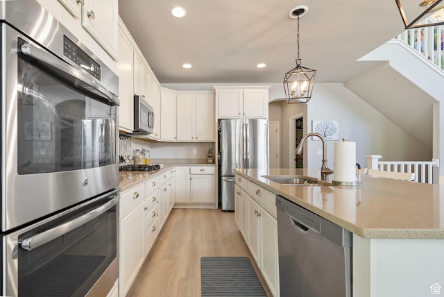 598 W Sandhill Dr, Lehi, UT 84043 - kitchen with appliances with stainless steel finishes, light wood-style flooring, recessed lighting, a kitchen island with sink, and hanging light fixtures