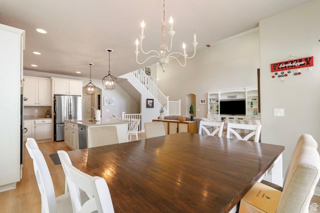 598 W Sandhill Dr, Lehi, UT 84043 - dining room with stairs, recessed lighting, light wood-type flooring, arched walkways, and a chandelier