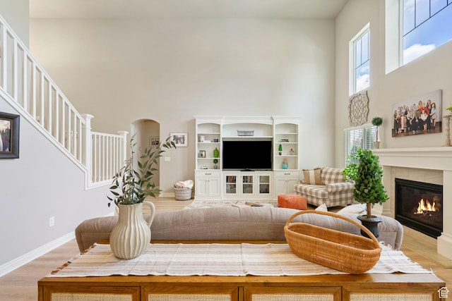 598 W Sandhill Dr, Lehi, UT 84043 - living area with a towering ceiling, a glass covered fireplace, light wood-style flooring, stairway, and arched walkways