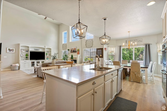 598 W Sandhill Dr, Lehi, UT 84043 - kitchen with a chandelier, light wood-style floors, dishwasher, a high ceiling, and a kitchen island with sink