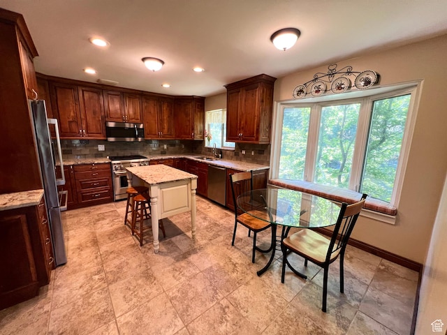 3550 E Oakview Dr, Millcreek, UT 84124 - kitchen featuring stainless steel appliances, backsplash, light stone countertops, a kitchen island, and recessed lighting