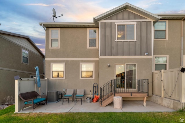 14584 S Heatherly Ln, Herriman, UT 84096 - rear view of property featuring board and batten siding, a gate, a patio, and stucco siding
