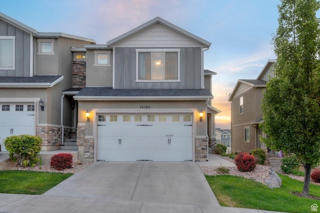 14584 S Heatherly Ln, Herriman, UT 84096 - view of front of home featuring board and batten siding, stone siding, an attached garage, and driveway