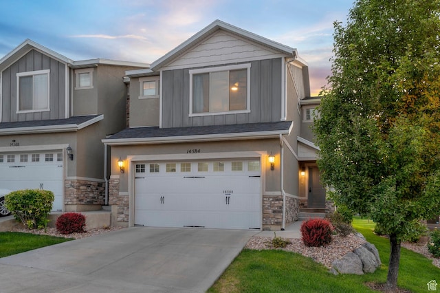 14584 S Heatherly Ln, Herriman, UT 84096 - view of front facade with board and batten siding, stone siding, an attached garage, and concrete driveway