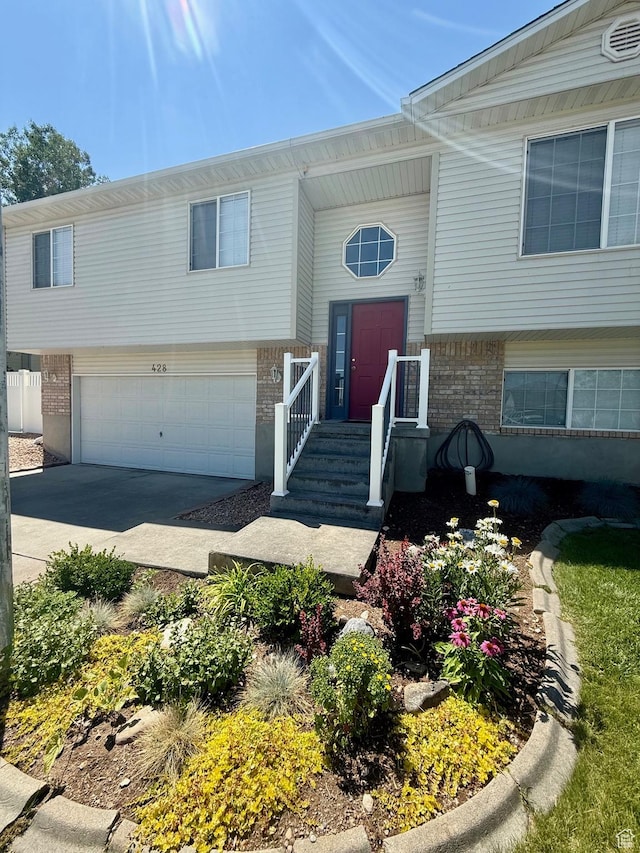428 E 810 N, Tooele, UT 84074 - bi-level home featuring brick siding, a garage, and concrete driveway
