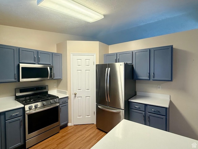 428 E 810 N, Tooele, UT 84074 - kitchen featuring appliances with stainless steel finishes, light wood-type flooring, light countertops, a textured ceiling, and gray cabinetry