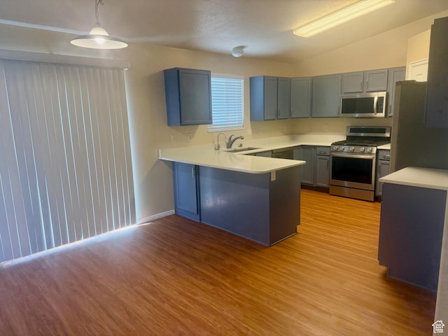 428 E 810 N, Tooele, UT 84074 - kitchen with stainless steel appliances, a peninsula, light wood-style floors, vaulted ceiling, and light countertops