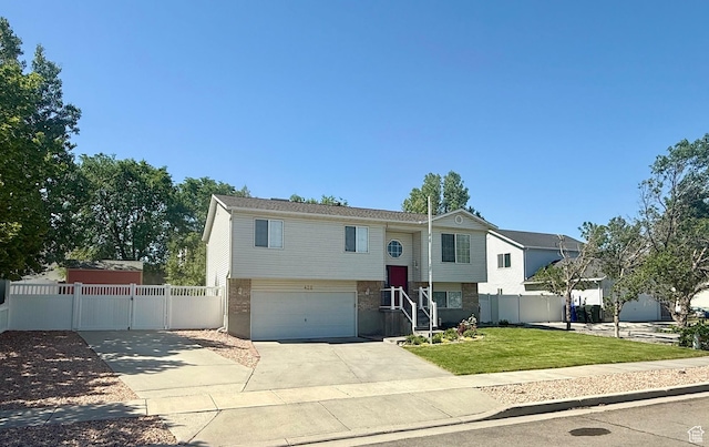 428 E 810 N, Tooele, UT 84074 - bi-level home with concrete driveway, brick siding, a garage, and a gate