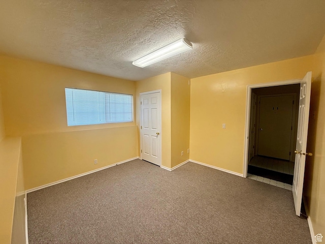 428 E 810 N, Tooele, UT 84074 - unfurnished bedroom with a textured ceiling and dark colored carpet