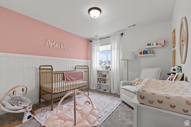 2488 W 2940 S, Syracuse, UT 84075 - carpeted bedroom featuring a wainscoted wall, a textured ceiling, and a crib
