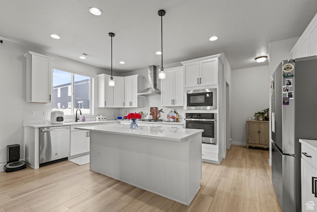 2488 W 2940 S, Syracuse, UT 84075 - kitchen featuring appliances with stainless steel finishes, wall chimney exhaust hood, light countertops, light wood-style flooring, and recessed lighting