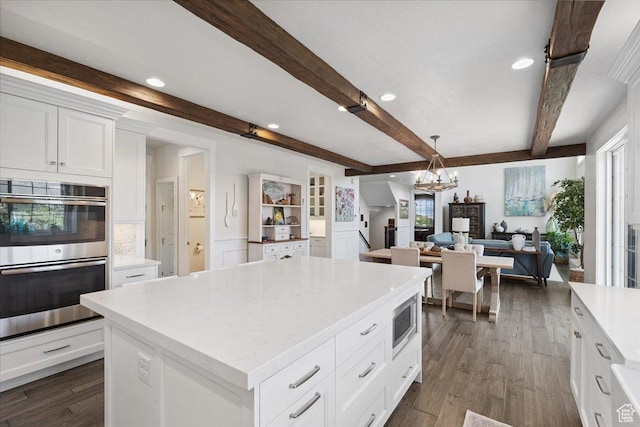 10865 S Hiddenwood Dr, Sandy, UT 84092 - kitchen with appliances with stainless steel finishes, a chandelier, beamed ceiling, white cabinetry, and plenty of natural light
