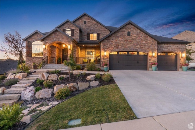 10865 S Hiddenwood Dr, Sandy, UT 84092 - view of front of house featuring covered porch, a garage, concrete driveway, and stone siding