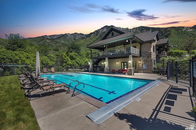 10865 S Hiddenwood Dr, Sandy, UT 84092 - pool at dusk featuring a patio, a community pool, and a mountain view