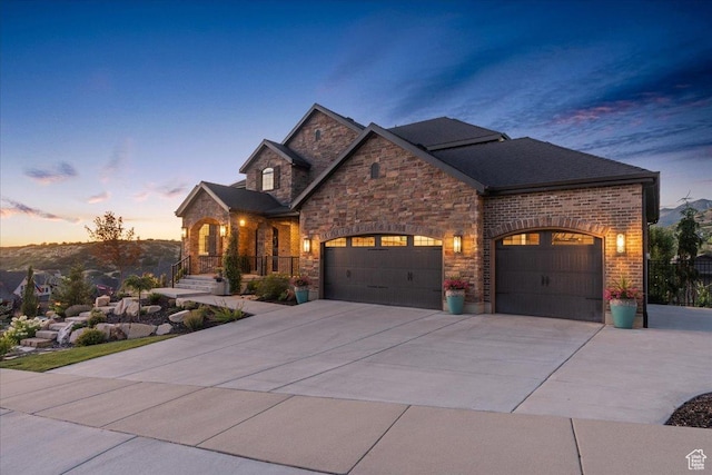 10865 S Hiddenwood Dr, Sandy, UT 84092 - view of front facade featuring a garage, driveway, and stone siding