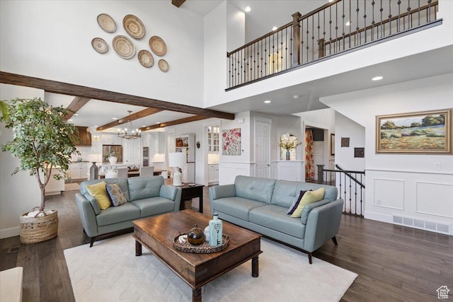 10865 S Hiddenwood Dr, Sandy, UT 84092 - living area featuring wood finished floors, a chandelier, a decorative wall, beamed ceiling, and a towering ceiling
