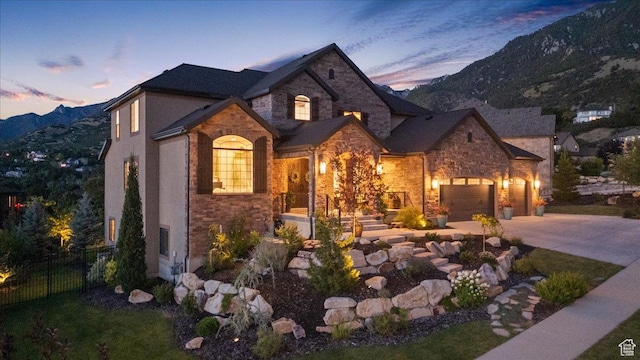 10865 S Hiddenwood Dr, Sandy, UT 84092 - view of front of home with stone siding, concrete driveway, and a mountain view