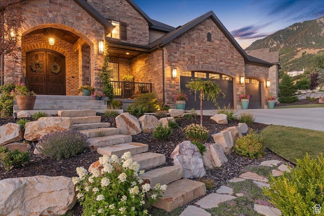 10865 S Hiddenwood Dr, Sandy, UT 84092 - view of front of property with an attached garage, covered porch, brick siding, concrete driveway, and stone siding