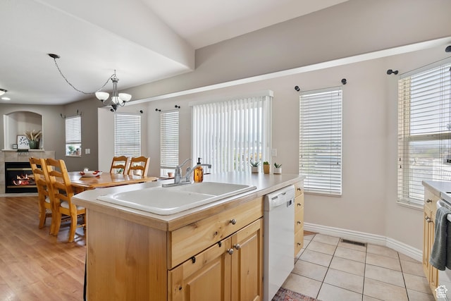 623 W 550 S, Centerville, UT 84014 - kitchen with white dishwasher, a chandelier, a tiled fireplace, and plenty of natural light