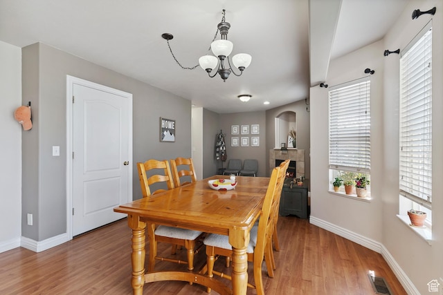 623 W 550 S, Centerville, UT 84014 - dining area featuring a chandelier, light wood finished floors, plenty of natural light, and arched walkways
