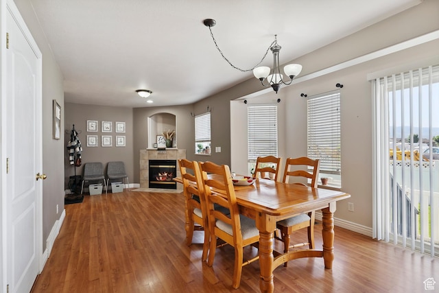 623 W 550 S, Centerville, UT 84014 - dining space with light wood-type flooring, a tiled fireplace, and a chandelier