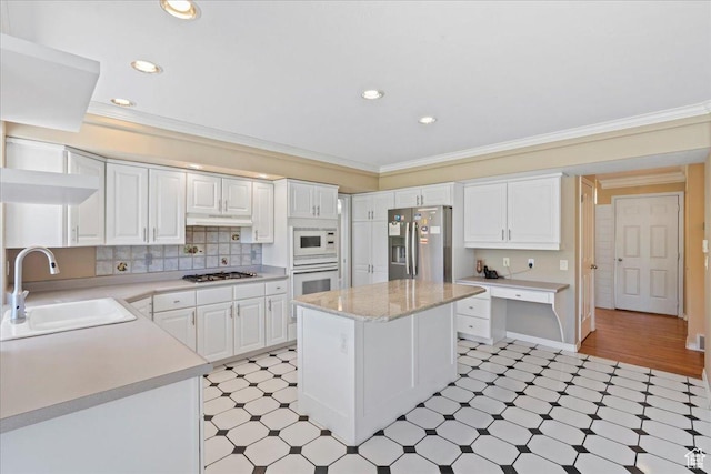 1116 W Wasatch Downs Dr, South Jordan, UT 84095 - kitchen with appliances with stainless steel finishes, light flooring, light countertops, crown molding, and under cabinet range hood