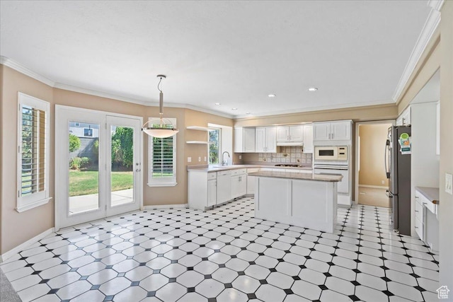 1116 W Wasatch Downs Dr, South Jordan, UT 84095 - kitchen featuring white appliances, white cabinets, ornamental molding, a kitchen island, and light countertops