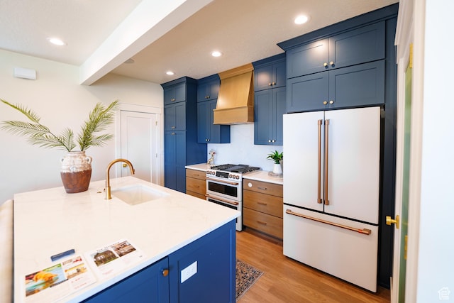 11448 S Watercourse Rd, South Jordan, UT 84009 - kitchen with premium appliances, blue cabinetry, premium range hood, light wood-style floors, and recessed lighting