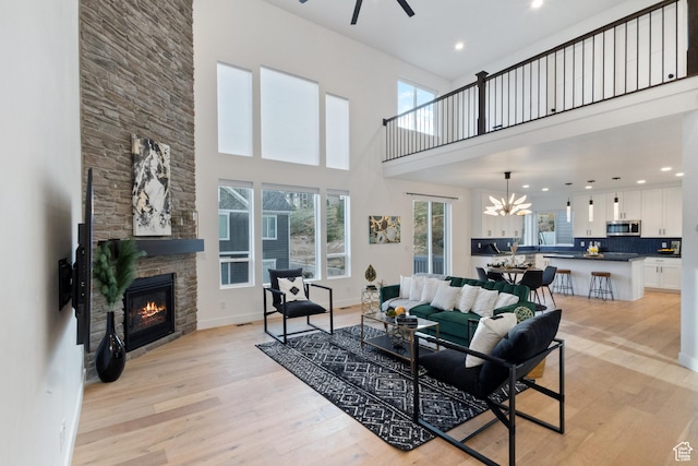 3973 N 900 W, Lehi, UT 84043 - living room featuring a fireplace, a ceiling fan, light wood-style floors, a high ceiling, and recessed lighting