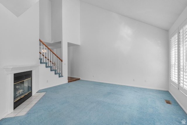 3548 E Wasatch Hills Ln S, Cottonwood Heights, UT 84121 - unfurnished living room with light colored carpet, healthy amount of natural light, a fireplace, stairs, and high vaulted ceiling
