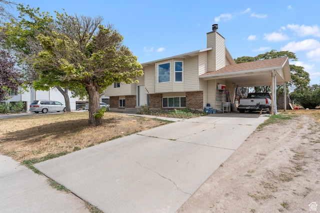 4323 W Benview Dr, West Valley City, UT 84120 - view of front facade featuring a carport, brick siding, driveway, and a chimney