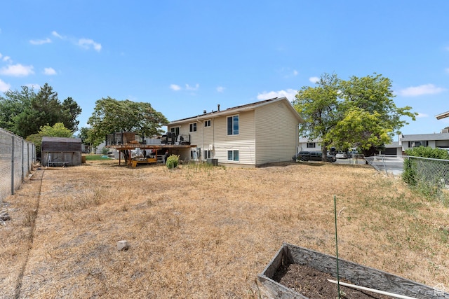 4323 W Benview Dr, West Valley City, UT 84120 - back of house with a wooden deck, a fenced backyard, a storage shed, and a vegetable garden