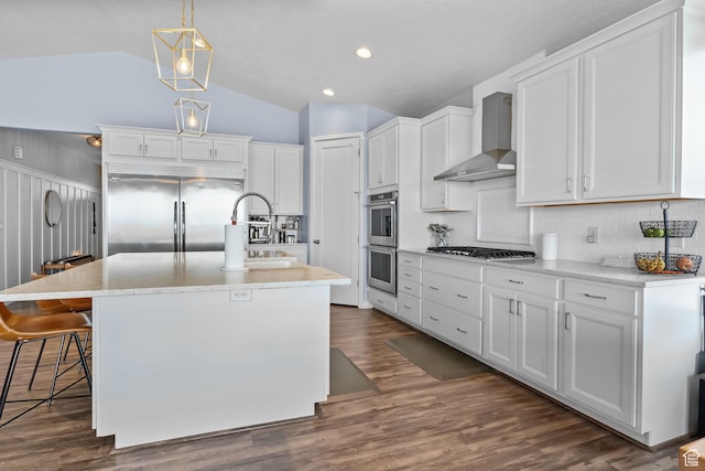 7603 S Scenic Maple Dr S, West Jordan, UT 84081 - kitchen with stainless steel appliances, wall chimney exhaust hood, vaulted ceiling, white cabinets, and decorative backsplash