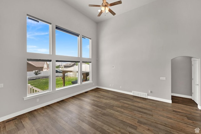 9602 N Blue Sky Dr, Eagle Mountain, UT 84005 - empty room with arched walkways, ceiling fan, hardwood / wood-style floors, and a towering ceiling