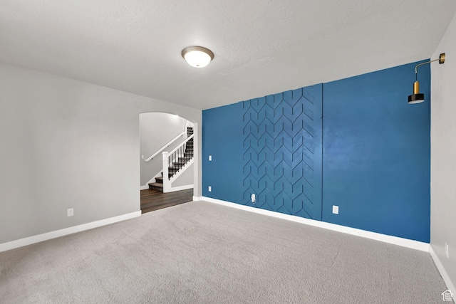 9602 N Blue Sky Dr, Eagle Mountain, UT 84005 - unfurnished room with arched walkways, carpet floors, stairway, and an accent wall