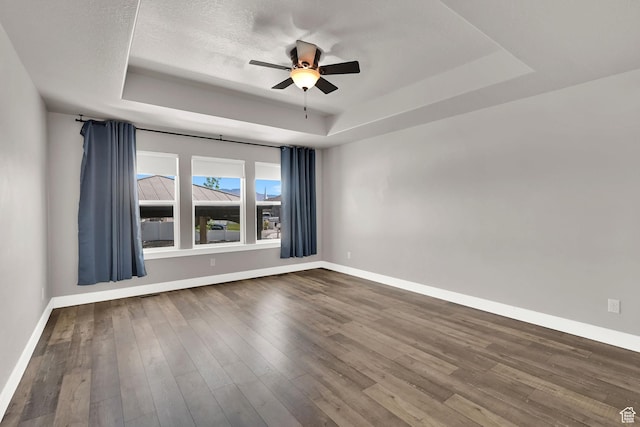 9602 N Blue Sky Dr, Eagle Mountain, UT 84005 - empty room with a raised ceiling, ceiling fan, and dark wood-style floors