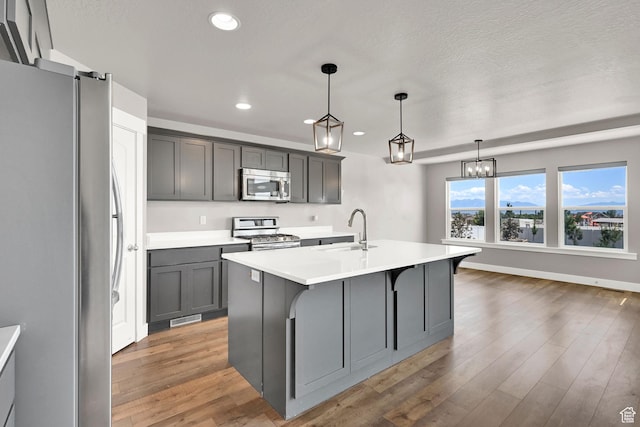 9602 N Blue Sky Dr, Eagle Mountain, UT 84005 - kitchen featuring stainless steel appliances, recessed lighting, light countertops, light wood-type flooring, and a center island with sink