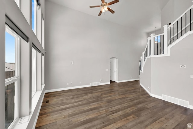9602 N Blue Sky Dr, Eagle Mountain, UT 84005 - unfurnished living room featuring a high ceiling, a ceiling fan, wood finished floors, stairs, and arched walkways