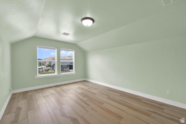 9602 N Blue Sky Dr, Eagle Mountain, UT 84005 - additional living space with a textured ceiling, lofted ceiling, and wood finished floors