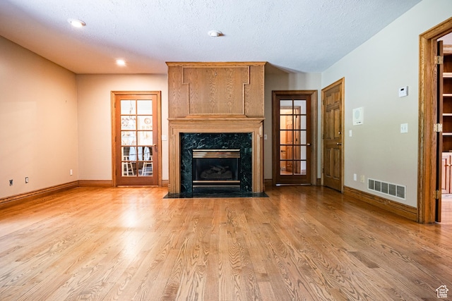 13251 S 1162 E, Draper, UT 84020 - unfurnished living room featuring wood finished floors, a high end fireplace, a textured ceiling, and recessed lighting