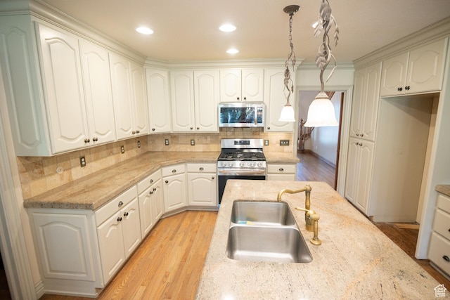 13251 S 1162 E, Draper, UT 84020 - kitchen with appliances with stainless steel finishes, tasteful backsplash, pendant lighting, light wood-style floors, and light stone counters