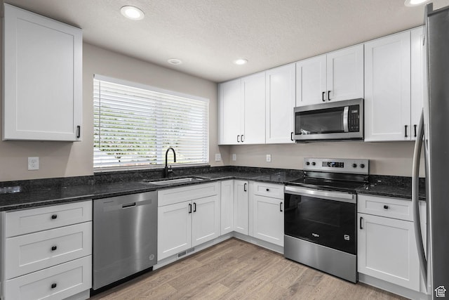 155 N 1600 W, West Point, UT 84015 - kitchen with stainless steel appliances, recessed lighting, a textured ceiling, light wood finished floors, and white cabinets