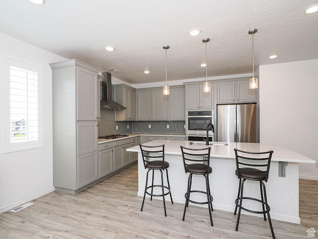 609 E 460 S, American Fork, UT 84003 - kitchen with stainless steel appliances, gray cabinetry, wall chimney range hood, light countertops, and a kitchen island with sink