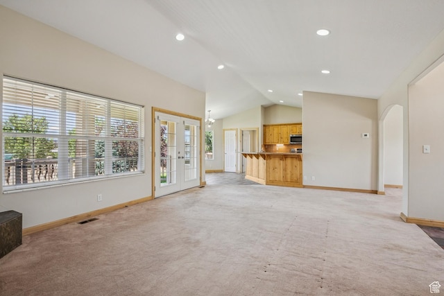 1516 S Lost Colt Dr, Heber City, UT 84032 - unfurnished living room featuring lofted ceiling, light carpet, arched walkways, recessed lighting, and french doors